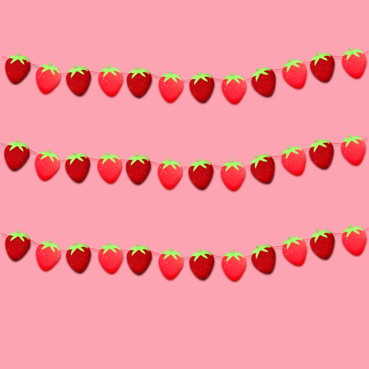 Strawberry first birthday garland hanging on a party wall backdrop