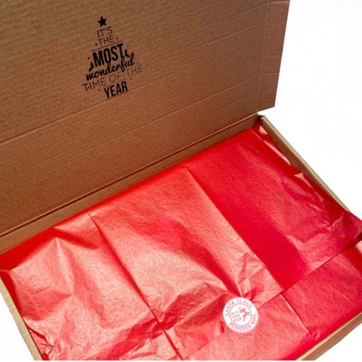 Open packaging box with red tissue paper and festive Christmas stamp, showing ready-to-gift presentation of the personalised Santa letter set